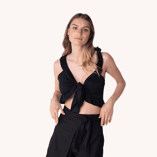 Blusa Marta Negra con tirantes, volantes y lazo en la parte delantera de MQM. Crop top femenino y moderno que resalta la figura, ideal para diversas ocasiones.