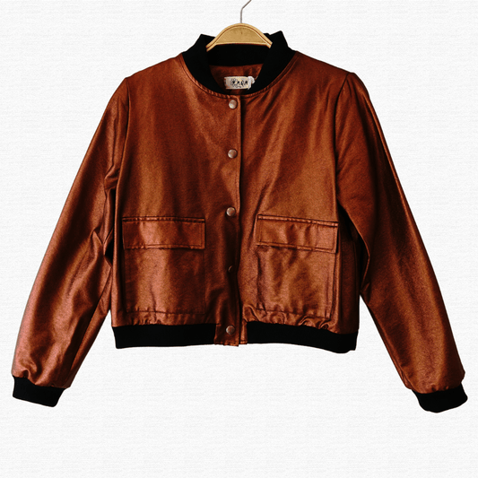 Chaqueta Bomber Jacket de ecocuero en color cobre de MQM para mujer, con botones con presillas y puños de algodón. Ideal para un look moderno y versátil, perfecta para cualquier ocasión, desde casual hasta salir de noche. Hecho a mano en Chile.