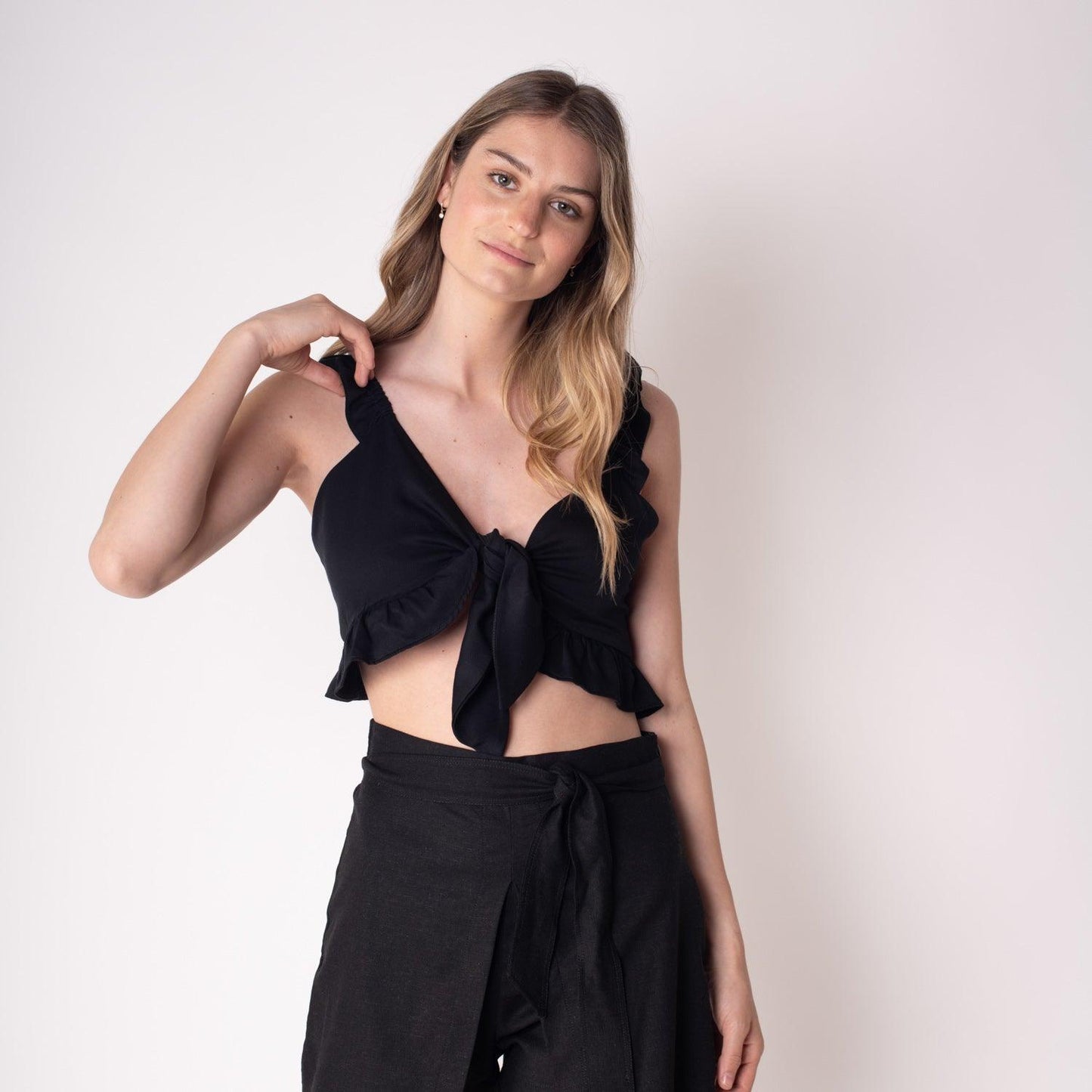 Blusa Marta Negra, de corte crop y con volantes en los tirantes, diseñada para un look elegante y femenino en cualquier ocasión