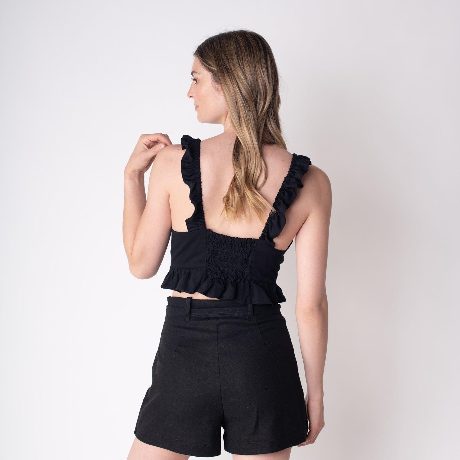 Blusa negra Marta, con diseño de tirantes con volantes y lazo, ideal para un estilo versátil y moderno en moda chilena