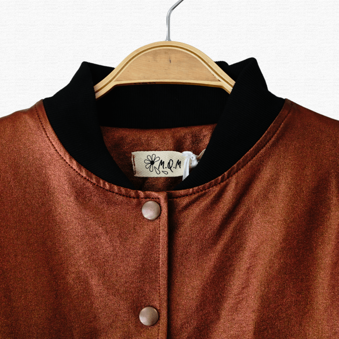 Chaqueta bomber de ecocuero en color cobre, con puños de algodón y botones, ideal para un look statement y moderno