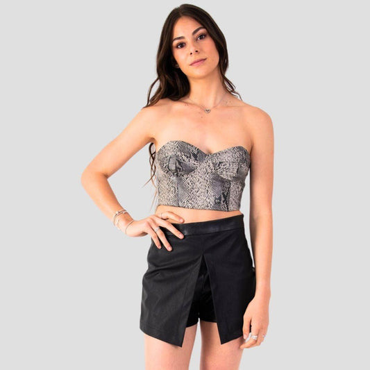 Corset de cuero estampado de culebra en negro, gris y blanco de MQM para mujer. Con escote en forma de V y sin mangas, este top ajustado se adapta perfectamente al cuerpo gracias a su tela de cuero PU de alta calidad. Hecho a mano en Chile.